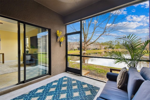 sunroom featuring a water view