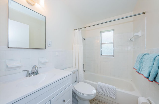 full bathroom with tile walls, vanity, toilet, and shower / tub combo with curtain