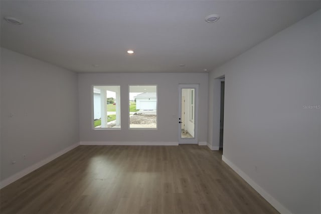 interior space with recessed lighting, wood finished floors, and baseboards