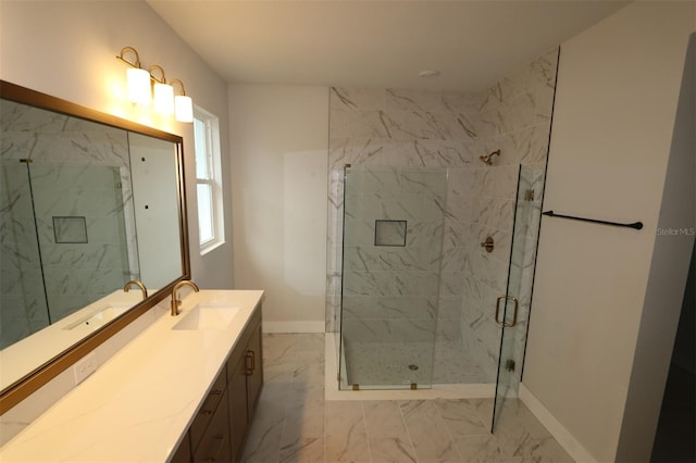 full bath with a marble finish shower, marble finish floor, vanity, and baseboards