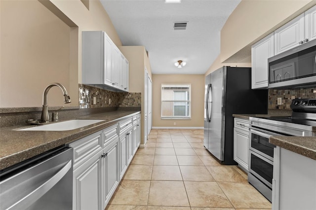 kitchen featuring white cabinetry, appliances with stainless steel finishes, sink, and light tile patterned floors