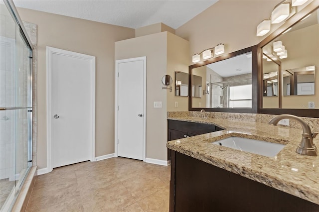 bathroom featuring vanity, tile patterned flooring, and a shower with door