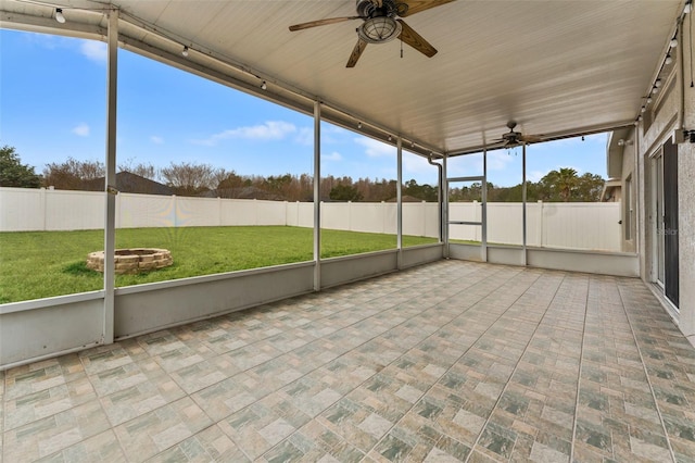 unfurnished sunroom with ceiling fan