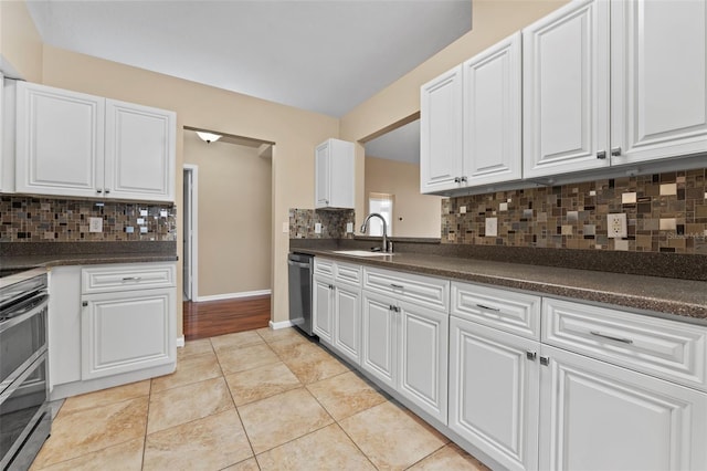 5809 War Admiral Dr, Wesley Chapel, FL 33544 - kitchen with stainless steel appliances, dark countertops, decorative backsplash, and white cabinetry