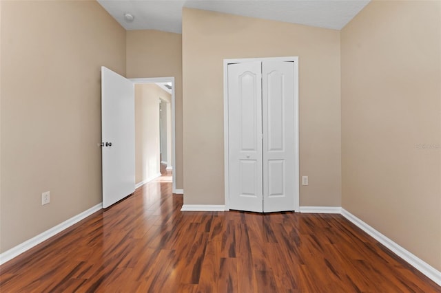 5809 War Admiral Dr, Wesley Chapel, FL 33544 - unfurnished bedroom featuring lofted ceiling, dark wood-type flooring, and a closet