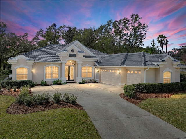 view of front of home featuring a garage and a lawn