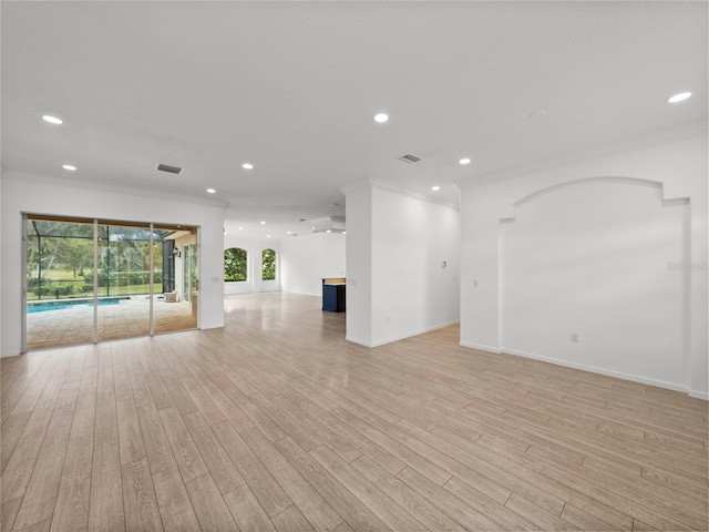 empty room with ornamental molding and light hardwood / wood-style flooring