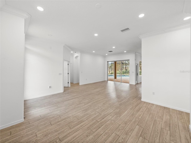 spare room featuring crown molding and light hardwood / wood-style floors