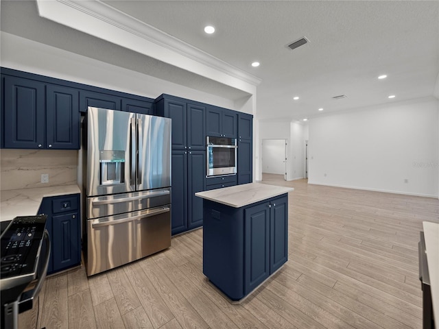 kitchen featuring stainless steel appliances, light stone countertops, and blue cabinetry