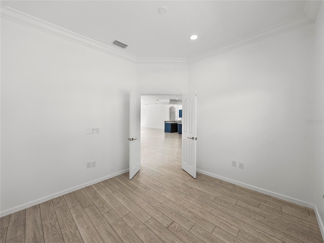 empty room featuring ornamental molding and light wood-type flooring