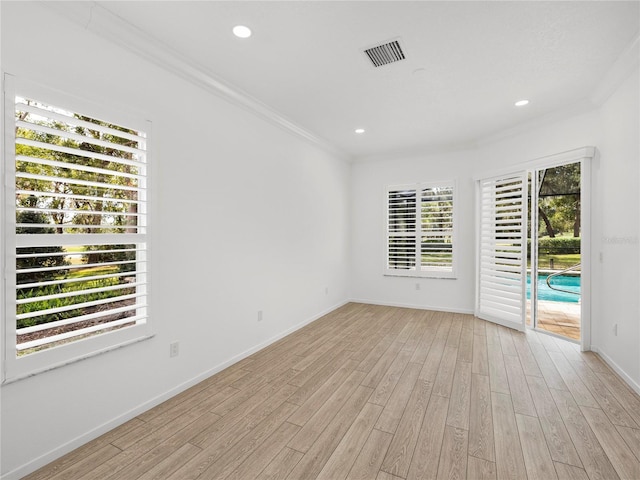 spare room featuring light hardwood / wood-style flooring and ornamental molding