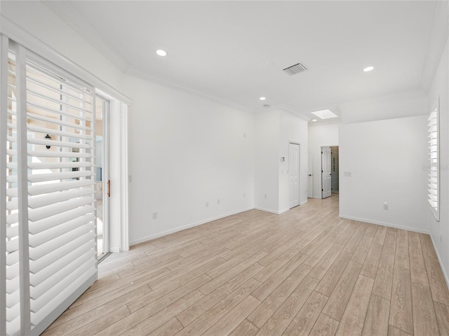 empty room featuring ornamental molding and light wood-type flooring