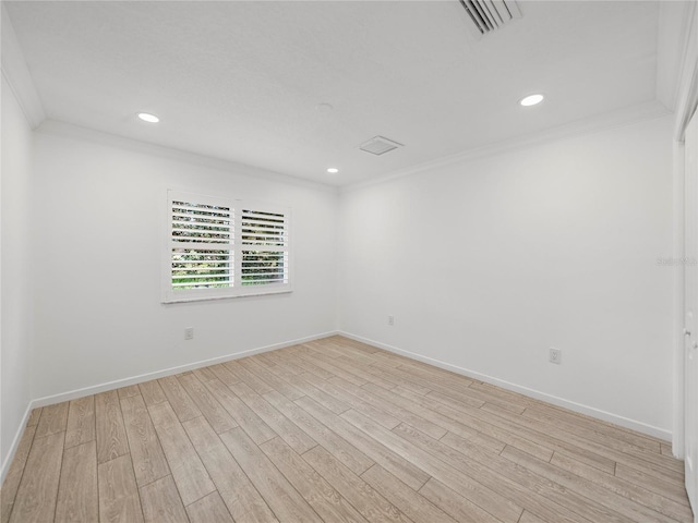 unfurnished room with ornamental molding and light wood-type flooring