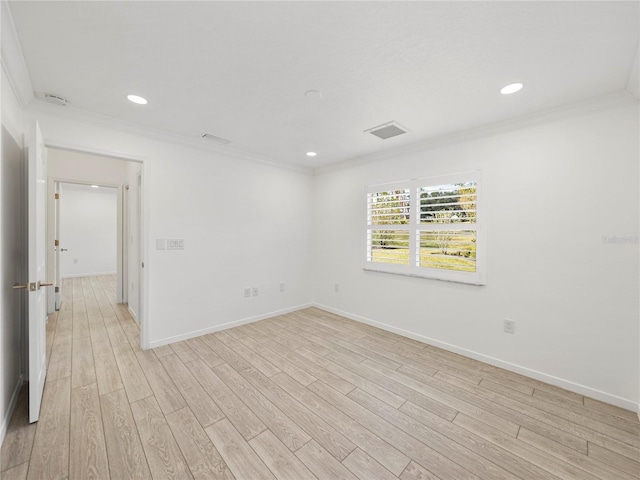 spare room featuring crown molding and light hardwood / wood-style flooring