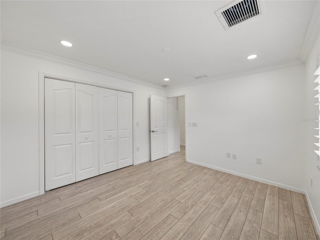 unfurnished bedroom featuring crown molding, a closet, and light hardwood / wood-style flooring