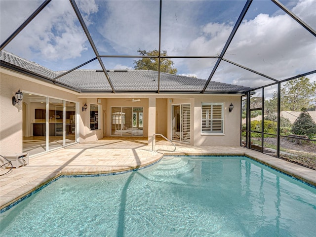 view of swimming pool featuring a patio area, ceiling fan, and glass enclosure