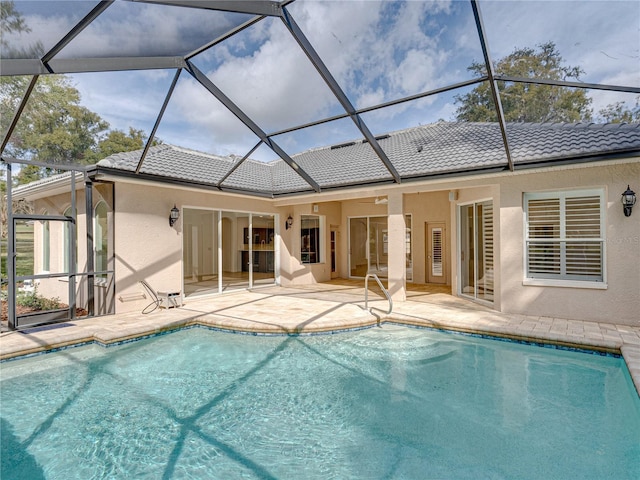 view of swimming pool featuring ceiling fan, a patio area, and glass enclosure