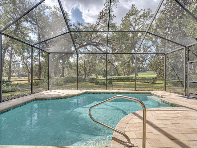 view of pool with a patio area and glass enclosure