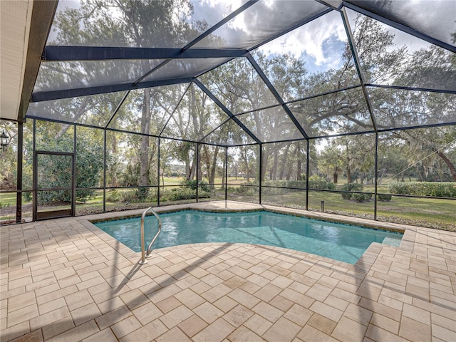 view of pool with a patio and glass enclosure