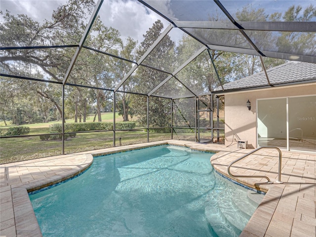 view of swimming pool with a lawn, a patio, and glass enclosure