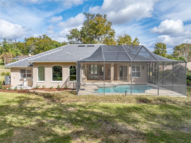 rear view of property featuring a lawn, cooling unit, glass enclosure, and a patio area