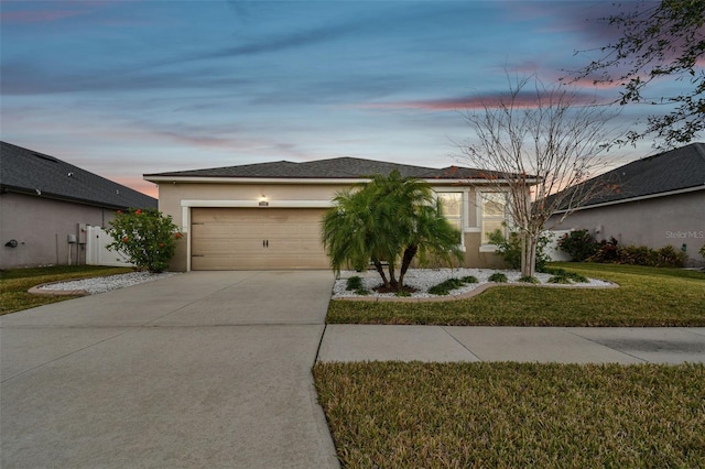 view of front of property with a garage and a yard