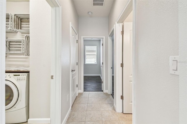 laundry area with washer / dryer and light tile patterned floors