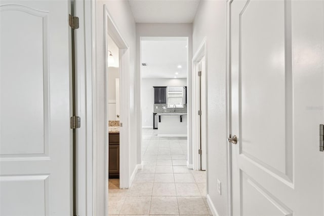 hall with light tile patterned floors and sink