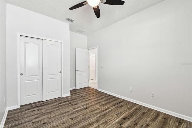 unfurnished bedroom featuring ceiling fan, dark wood-type flooring, a closet, and a textured ceiling