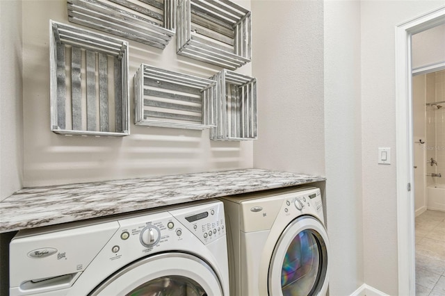 laundry area with light tile patterned flooring and washer and dryer