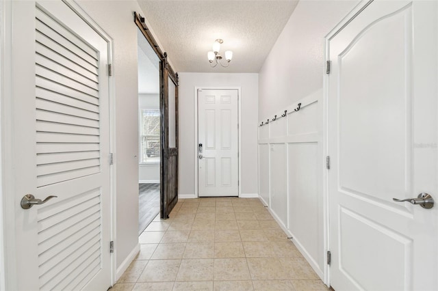 entryway featuring light tile patterned flooring, a barn door, and a textured ceiling