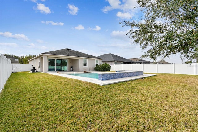 back of property featuring a fenced in pool, a patio area, and a lawn