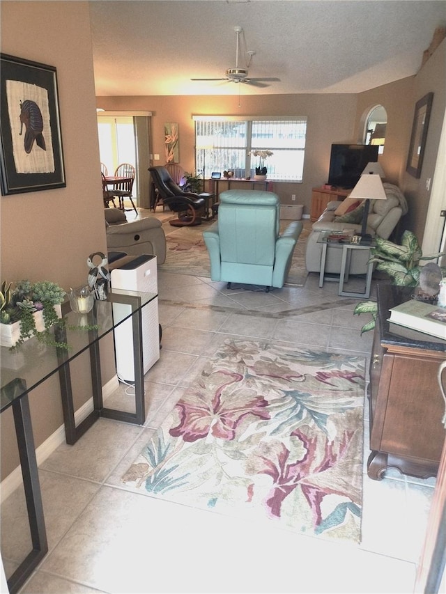 tiled living room featuring ceiling fan