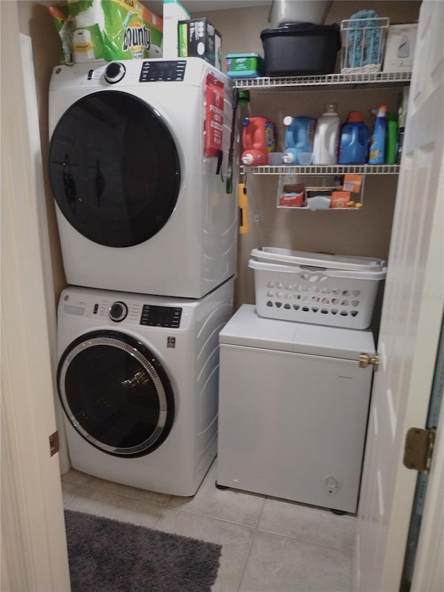 washroom featuring light tile patterned flooring and stacked washing maching and dryer