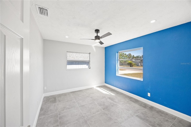 empty room with ceiling fan and a textured ceiling