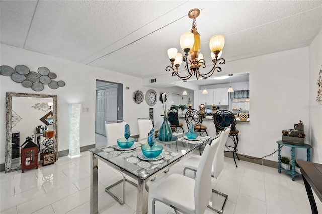 dining space featuring an inviting chandelier, a textured ceiling, and light tile patterned flooring