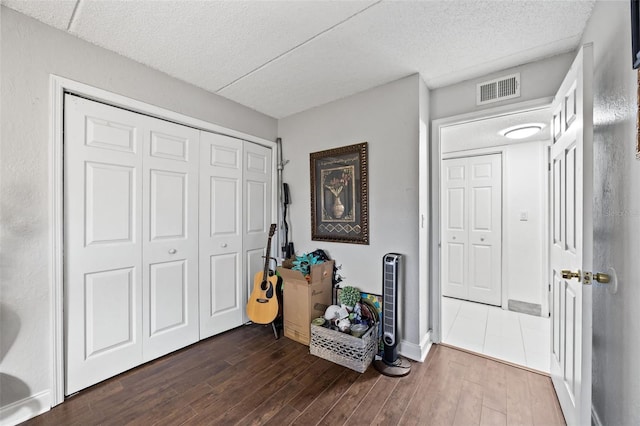 entrance foyer with dark hardwood / wood-style flooring and a textured ceiling