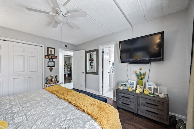 bedroom featuring dark wood-type flooring, connected bathroom, ceiling fan, and a closet