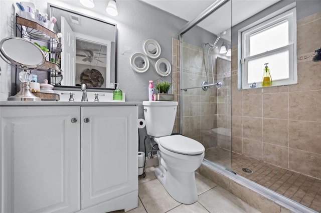 bathroom with vanity, tile patterned floors, a shower with door, and toilet