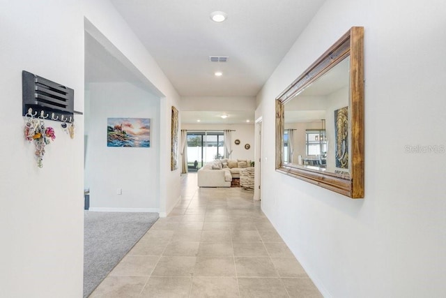 hall with light colored carpet