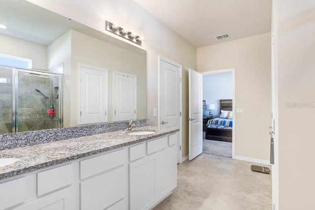 bathroom featuring vanity, tile patterned flooring, and a shower with door