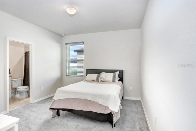 bedroom featuring light colored carpet and connected bathroom