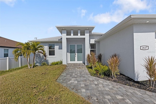 view of front facade with a front yard and french doors