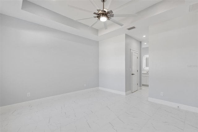 spare room featuring ceiling fan and a tray ceiling