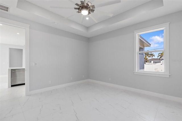 unfurnished room featuring ceiling fan and a tray ceiling