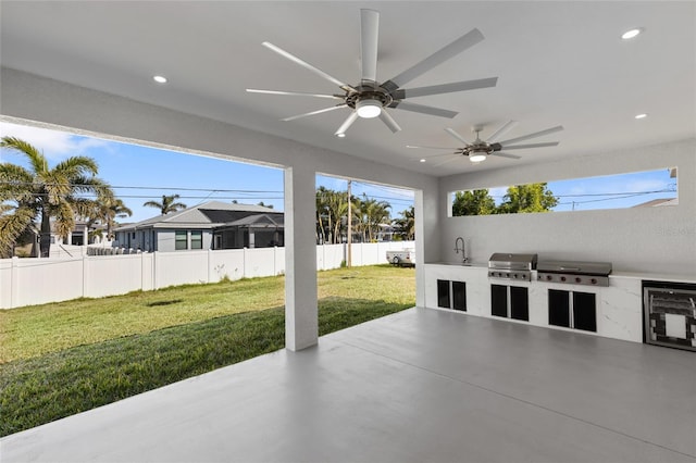 view of patio with area for grilling, sink, ceiling fan, and an outdoor kitchen