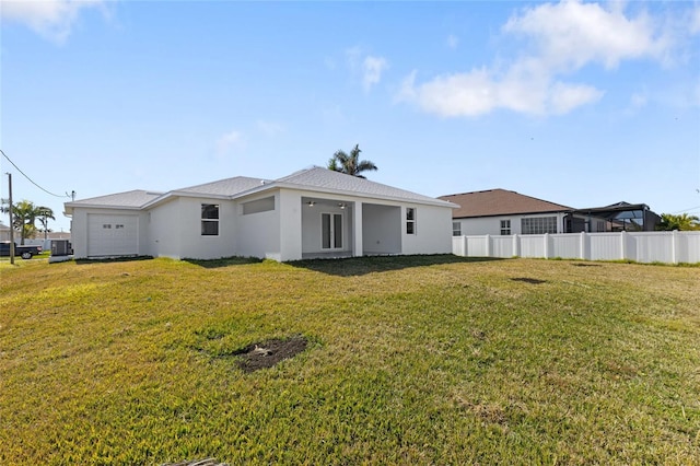 back of house with a garage and a yard