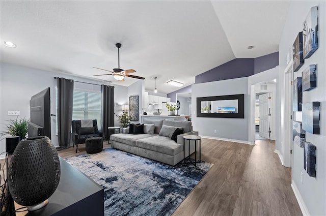 living room featuring ceiling fan, lofted ceiling, and wood-type flooring