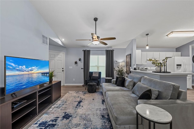 living room with ceiling fan, wood-type flooring, and vaulted ceiling