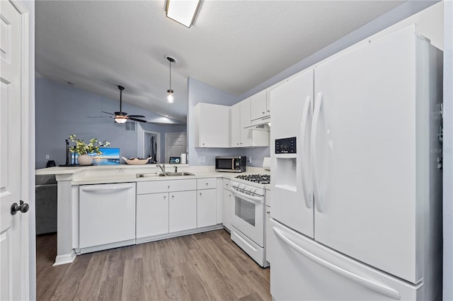 kitchen featuring sink, white appliances, white cabinetry, vaulted ceiling, and light wood-type flooring